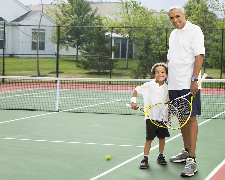 Black father and son playing tennis Photograph by Jose Luis Pelaez Inc