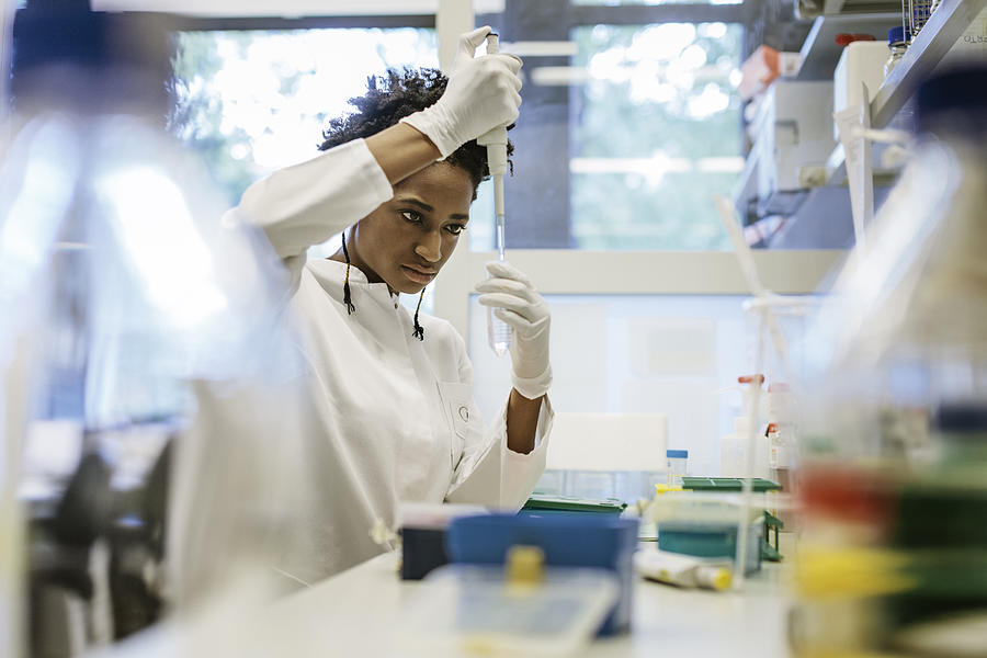 Black female scientist pipetting in a laboratory Photograph by Hinterhaus Productions