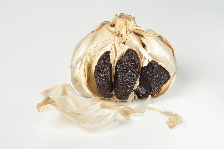 Black garlic on white background, close-up Photograph by Image Professionals GmbH