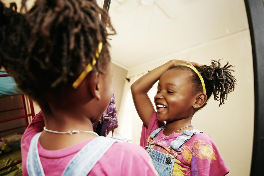 Black girl admiring herself in mirror Photograph by Peathegee Inc