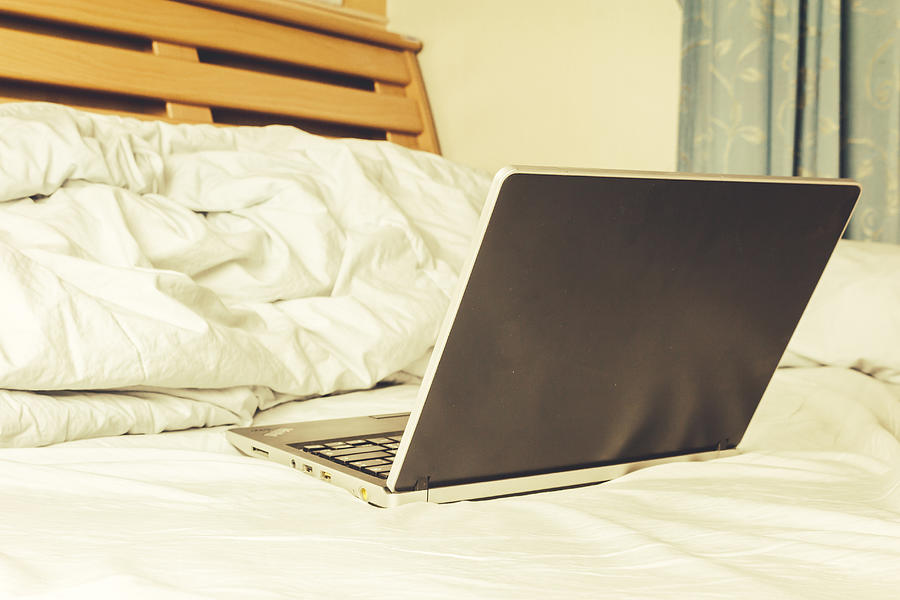 Black laptop on the bed Photograph by Arto_canon