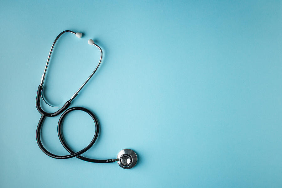Black stethoscope on blue background Photograph by Roman Valiev