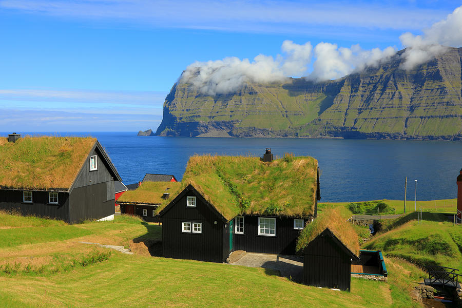 Black wooden houses with grassy roofs in a small northern village on the shore of the sea Photograph by Rainer Grosskopf