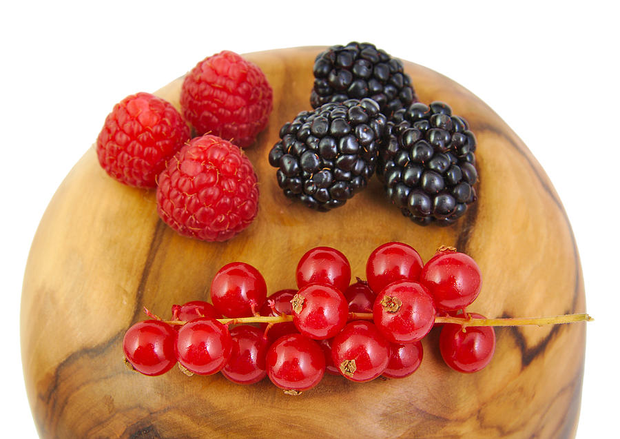 Blackberries, red currants and raspberries on a olive wood surface Photograph by Jorgecachoh