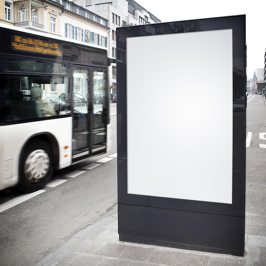 Blank advertising billboard on city street, bus passes Photograph by Ollo
