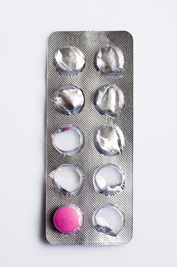 Blister pack with one pink pill remaining, close-up Photograph by Burakpekakcan