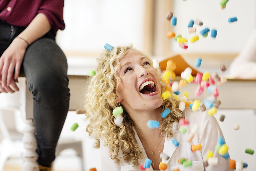 Blond businesswoman laughing about falling marshmellows Photograph by Westend61