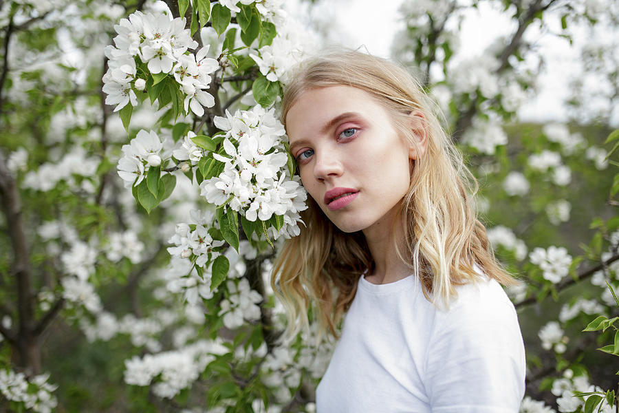 Blond haired young woman among white blossoms Photograph by Vyacheslav Chistyakov
