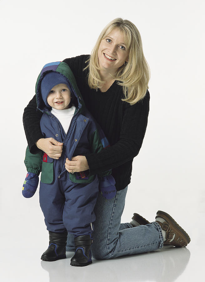 Blonde Mom Kneels Behind Young Son Putting His Coat On With A Smile Photograph by Photodisc