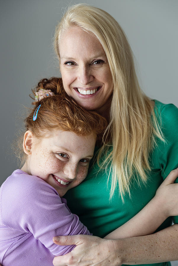 Blonde mother and expressive preteen redhead daughter portrait. Photograph by Martinedoucet