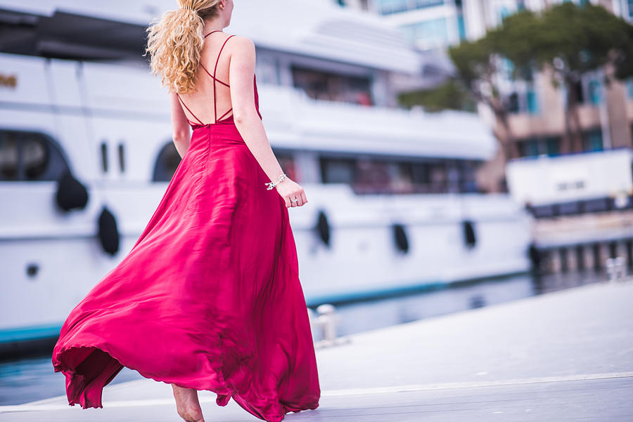 Blondie lady in red silk dress running away. Photograph by Isbjorn