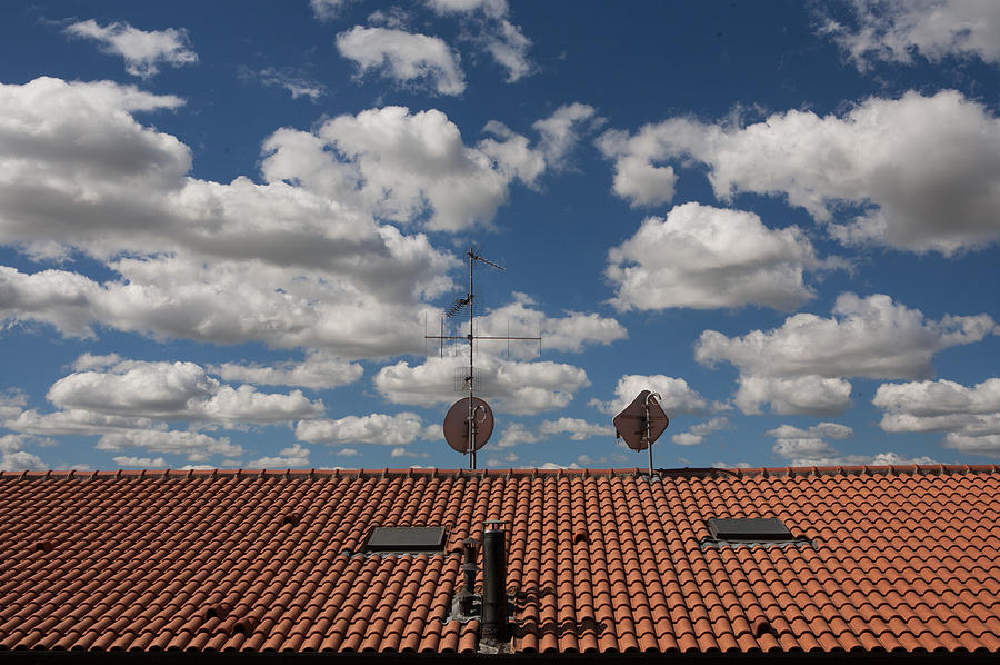 Blue Cloudy Sky Over A Red Roof Photograph by Francesca Cambi