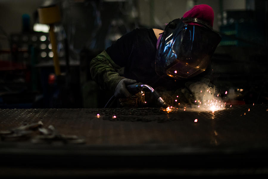 Blue collar woman at work. Female welder working in a workshop Photograph by MmeEmil