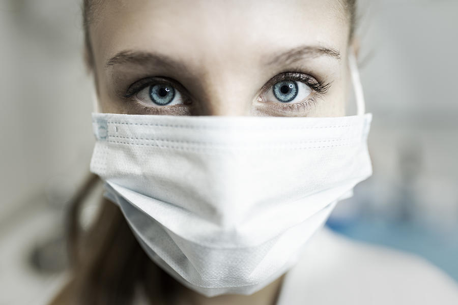 Blue-eyed nurse at her workplace wearing a protective mask. Photograph by Alan Rubio