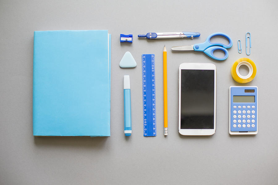 Blue school supplies on grey background Photograph by Fotostorm