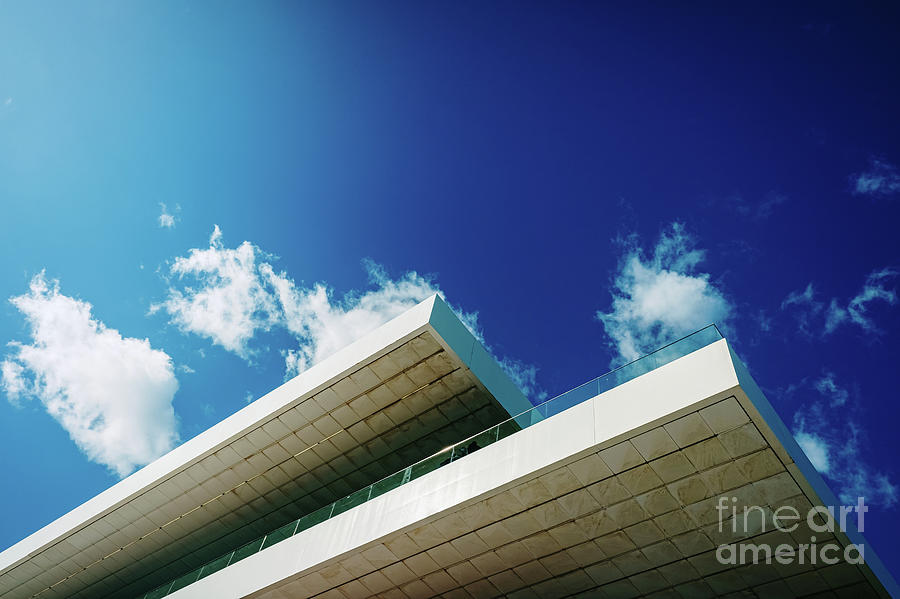 Blue sky background with clouds and a roof of modern financial business building. Photograph by Joaquin Corbalan