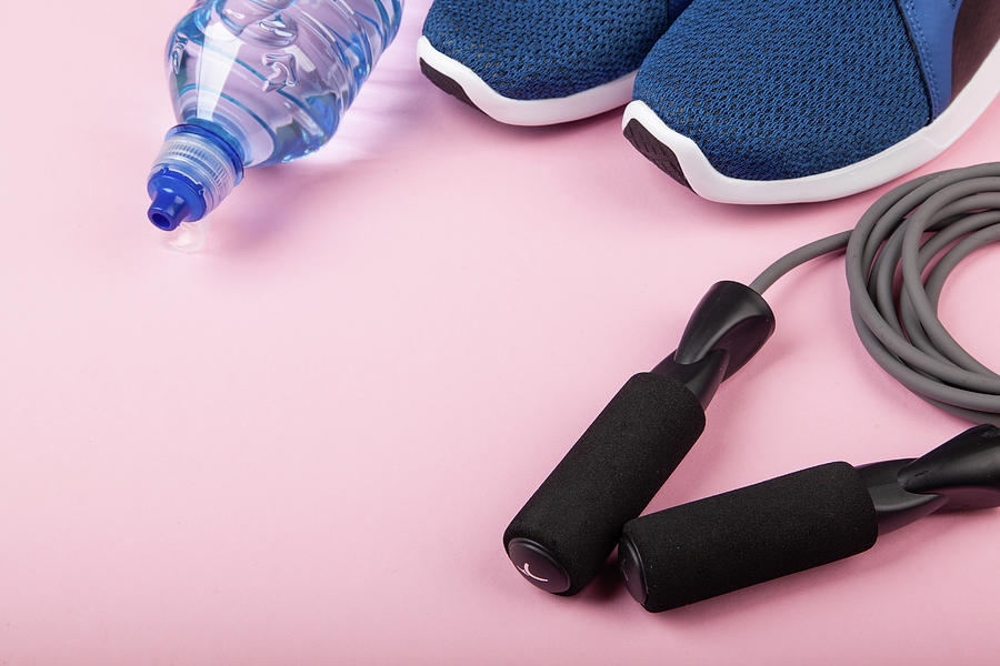 Blue Sneakers, Skipping Rope And Bottle Of Water On Pink Background. Concept Of Healthy Lifestile, Everyday Training And Force Of Will Photograph