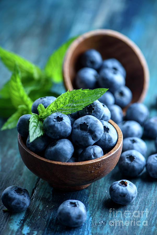 Blueberries in wooden bowl with mint leaf Photograph by Jelena Jovanovic