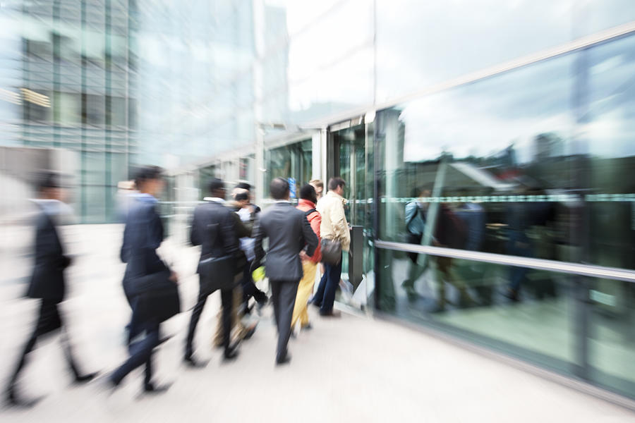 Blurred Business People Entering Office Building Through Glass Doors Photograph by Bim