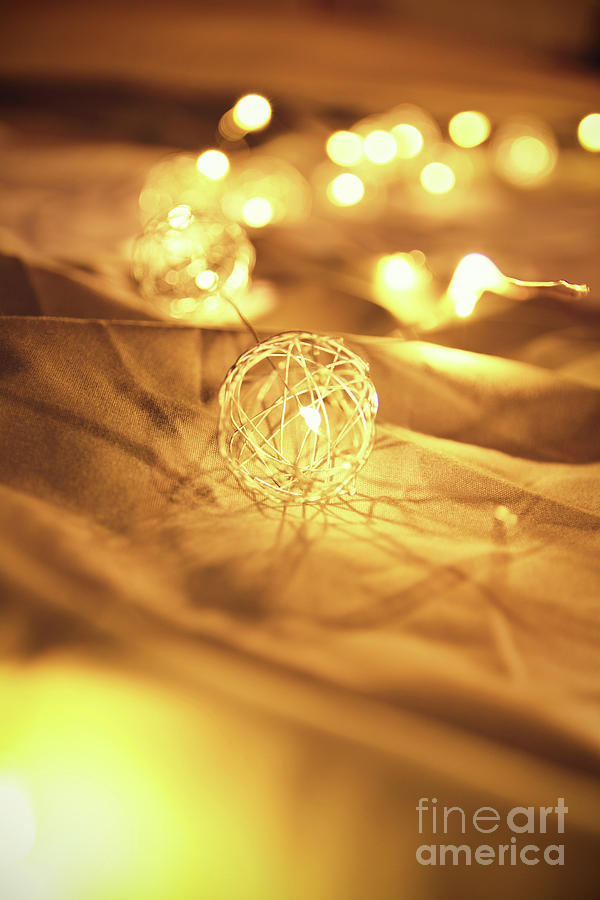 Blurred golden Christmas lights on rumpled bed sheets Photograph by Mendelex Photography