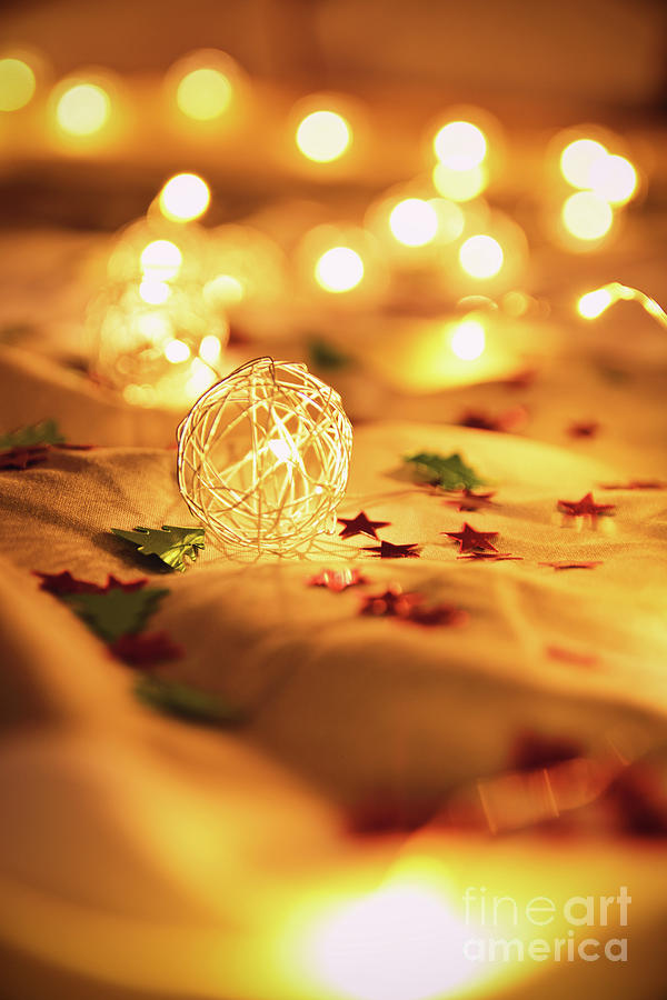 Blurred golden Christmas lights with decorations on rumpled bed  Photograph by Mendelex Photography