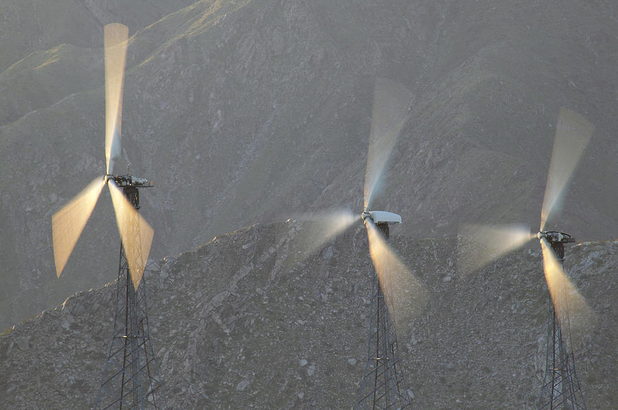 Blurred Motion Shot of Three Wind Turbines Against a Rocky Background Photograph by Digital Vision.