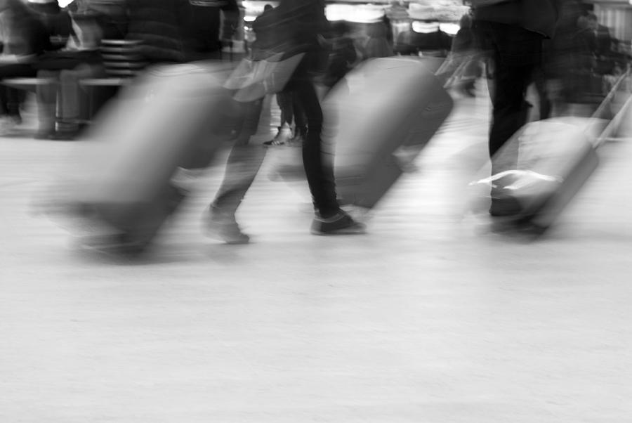 Blurred movement of Travellers with luggage Photograph by Lyn Holly Coorg