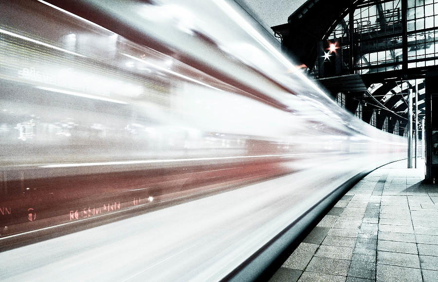 Blurred train at night leaving station Photograph by Bernd Schunack