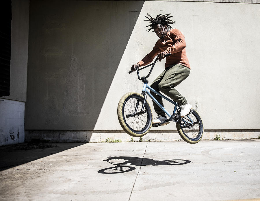 BMX rider performing jump in outdoor industrial environment Photograph by MoMo Productions