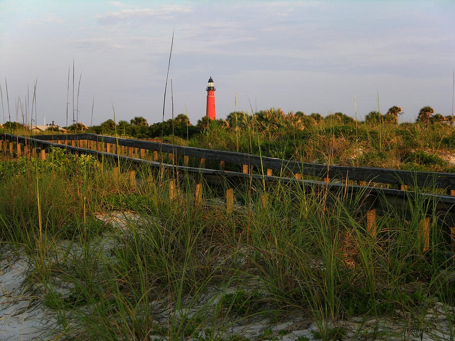 Boardwalk and lighthouse Photograph by Julianne Felton