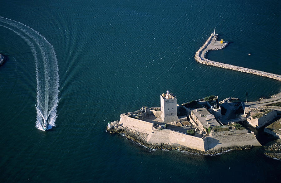 Boat passing along the fort of Fos-Sur-Mer, France (aerial view) Photograph by Sami Sarkis