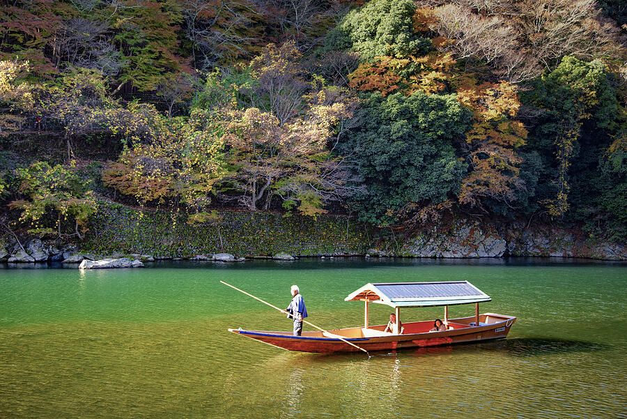 Boatman punting Tourist Sightseeing Boat along Katsura River, Arashiyama , Kyoto, Japan in Autumn Photograph by DoctorEgg