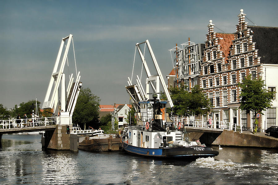 Boats crossing through the Gravestenenbrug drawbridge on the Spaarne River in Haarlem, Netherlands Photograph by Photo by Victor Ovies Arenas