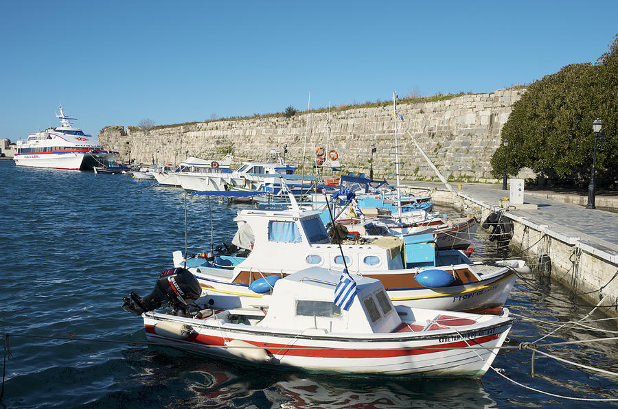 Boats in Kos Town Harbour before a wall of the Castle of the Knights. Photograph by Craig Pershouse