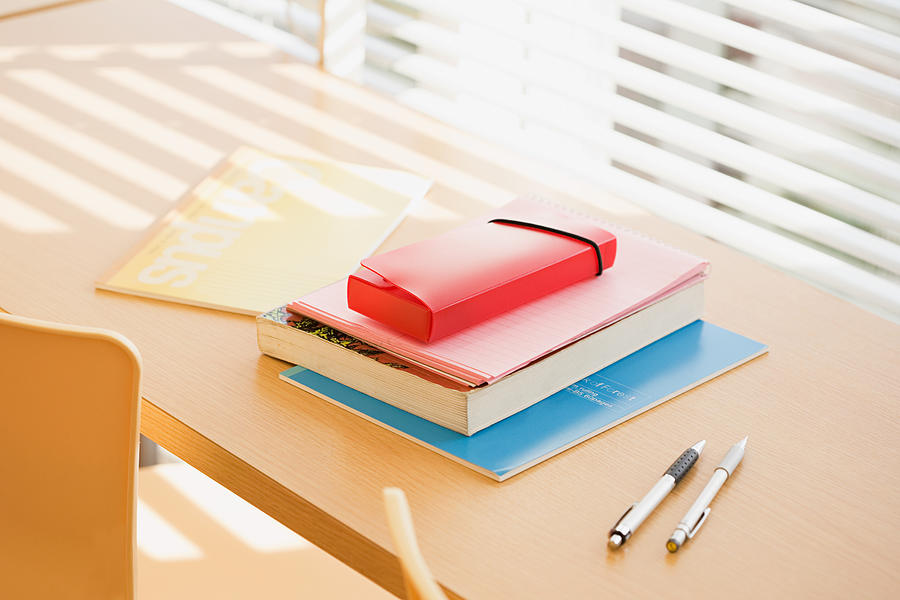 Books and pens on desk Photograph by Image Source