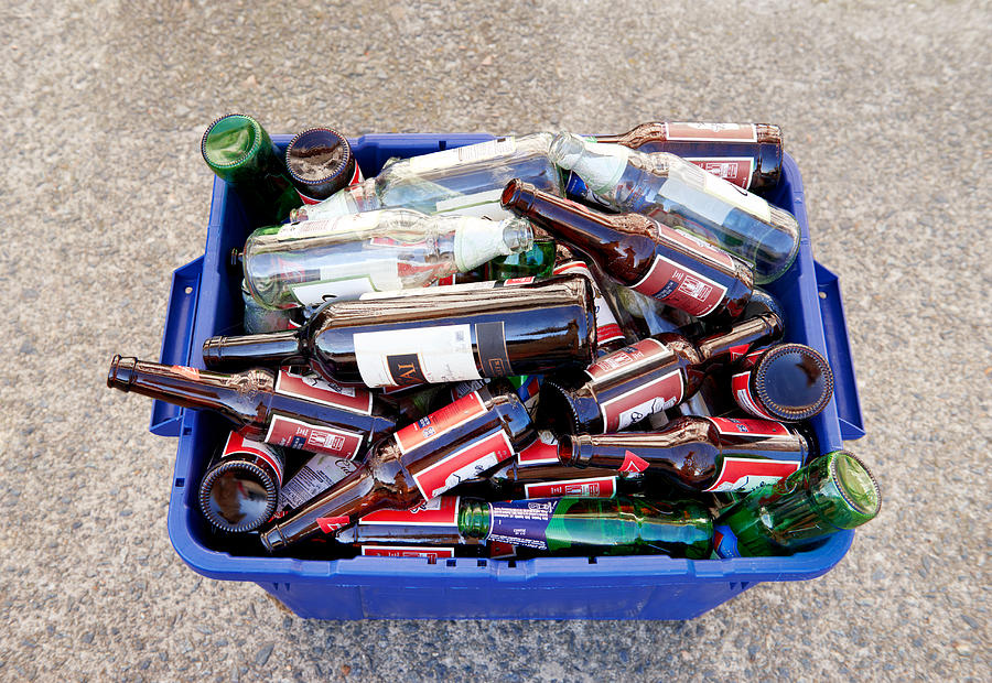 Bottle recycling in bin Photograph by Peter Dazeley