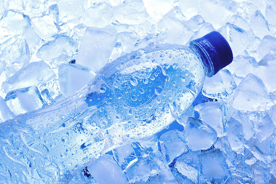 Bottled water with ice cubes Photograph by Imagehit