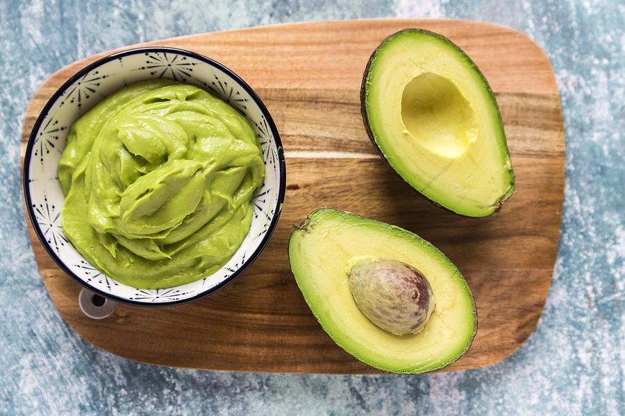 Bowl of guacamole and sliced avocado Photograph by Lacaosa