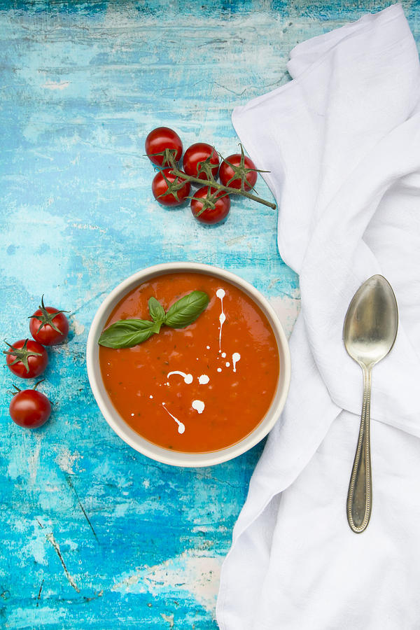 Bowl Of Tomato Soup On Blue Surface Photograph by Larissa Veronesi