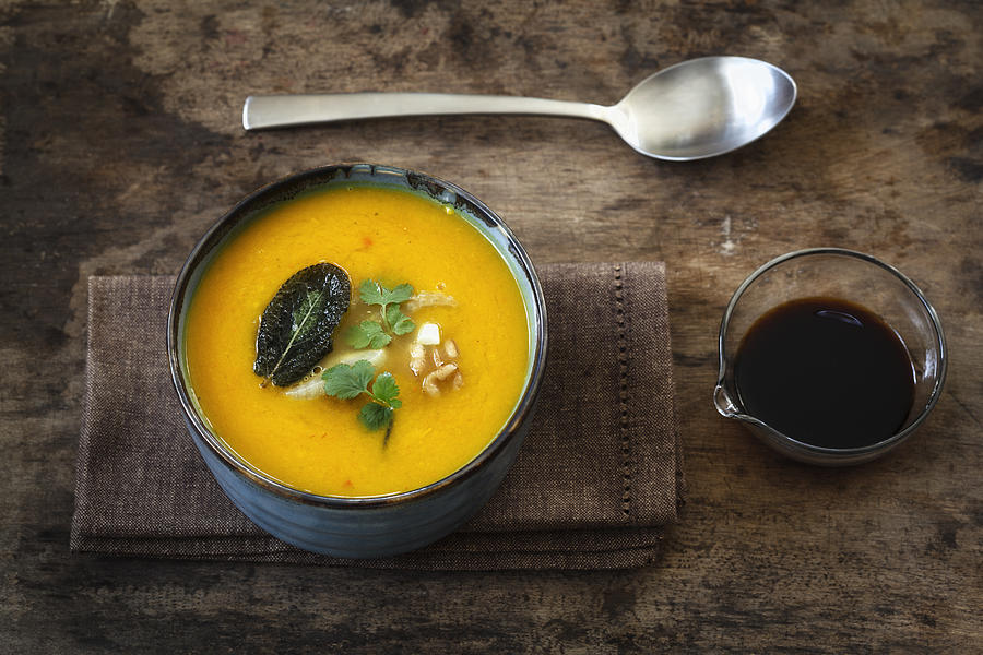 Bowl of vegan creamed pumpkin soup with walnuts and soy sauce Photograph by Westend61