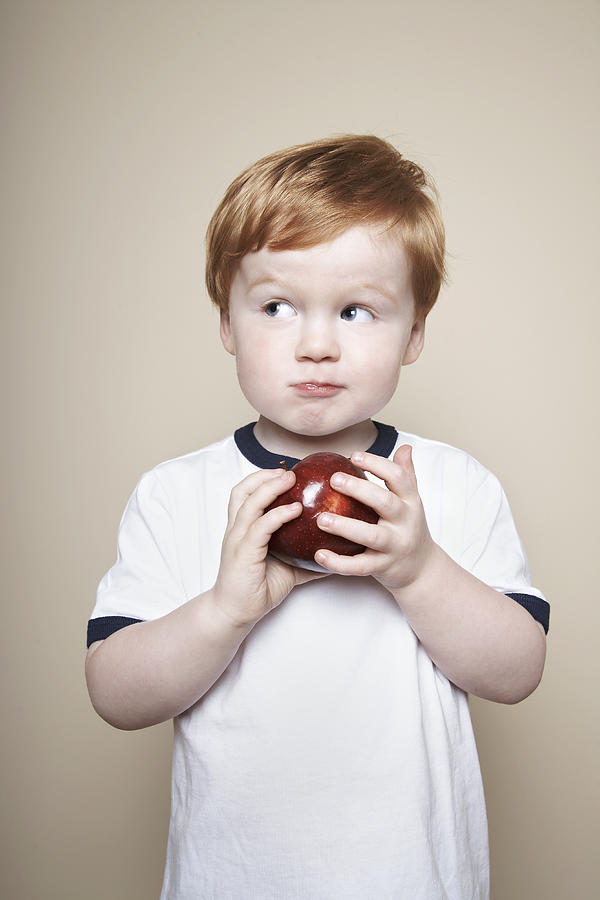 Boy, 3 years old, holding an apple. Photograph by Dan Hallman