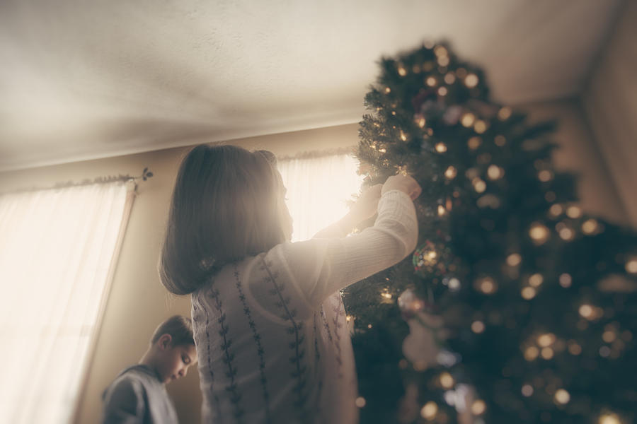boy and girl decorating Christmas tree Photograph by Rebecca Nelson