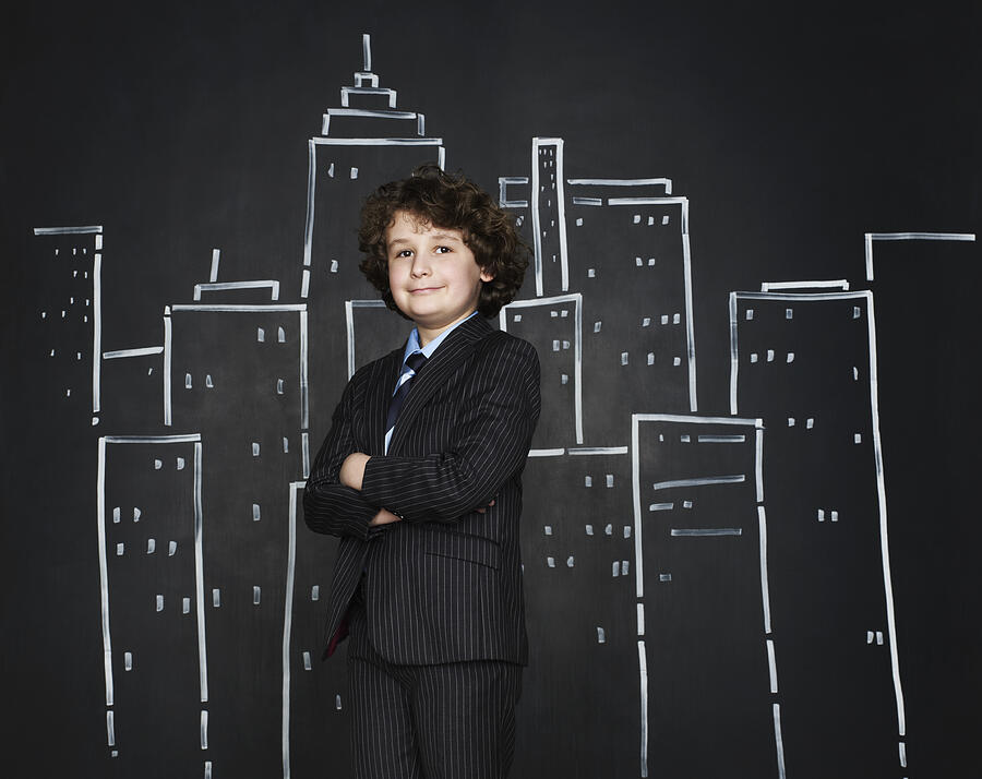 Boy as a businessman with cityscape background Photograph by Flashpop