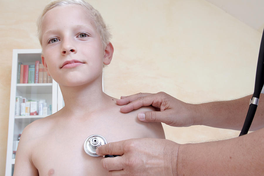 Boy being examining by doctor with stethoscope Photograph by Sigrid Gombert