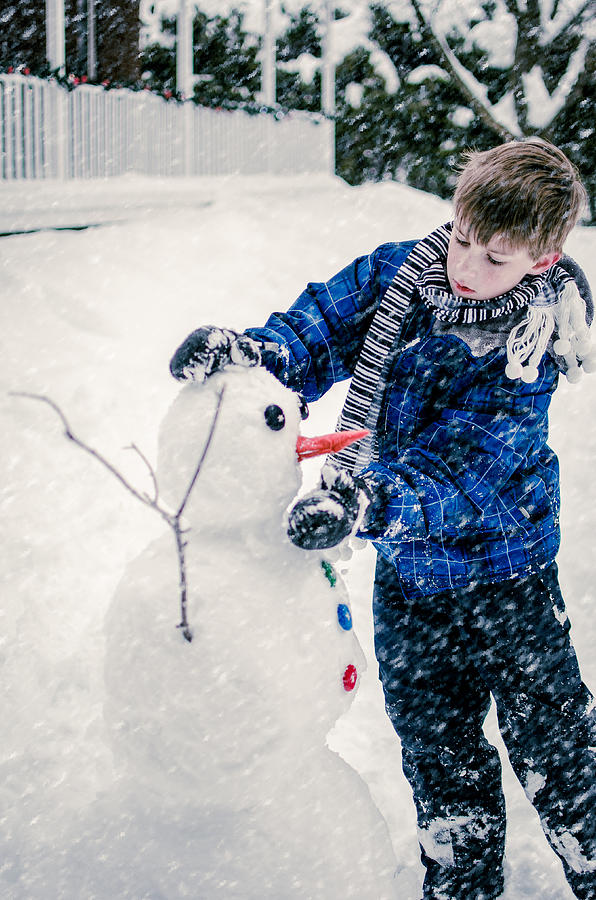Boy building a snowman Photograph by Danielle Donders