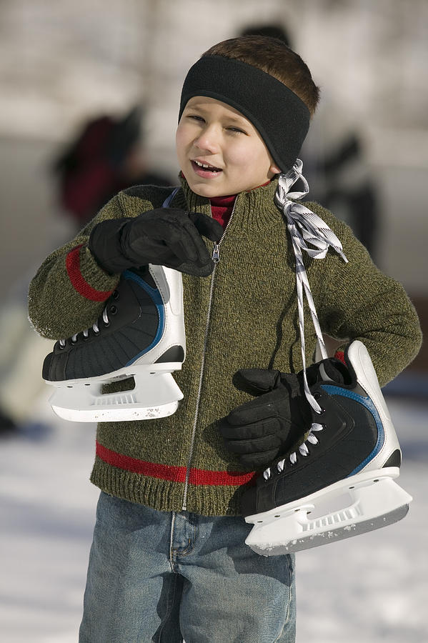 Boy carrying ice skates Photograph by Comstock Images