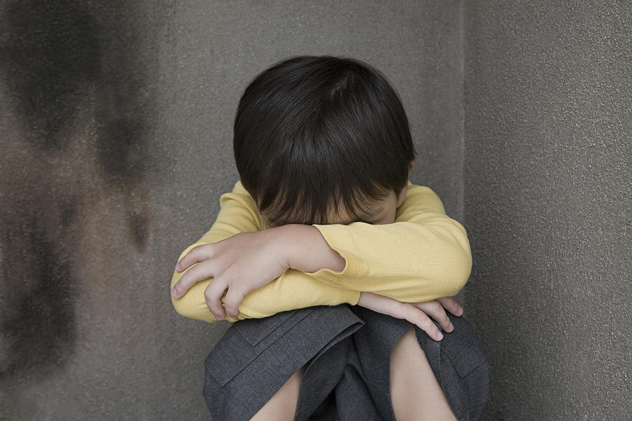 Boy crying in a corner Photograph by Image Source