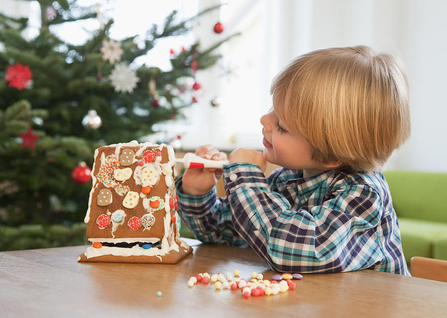 Boy Decorating Gingerbread House Photograph by Henglein and Steets