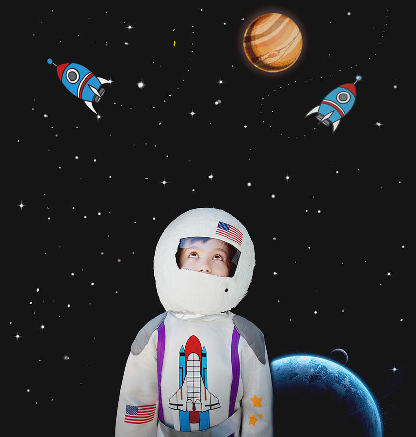 Boy dressed as astronaut.Cartoon in background Photograph by Carol Yepes