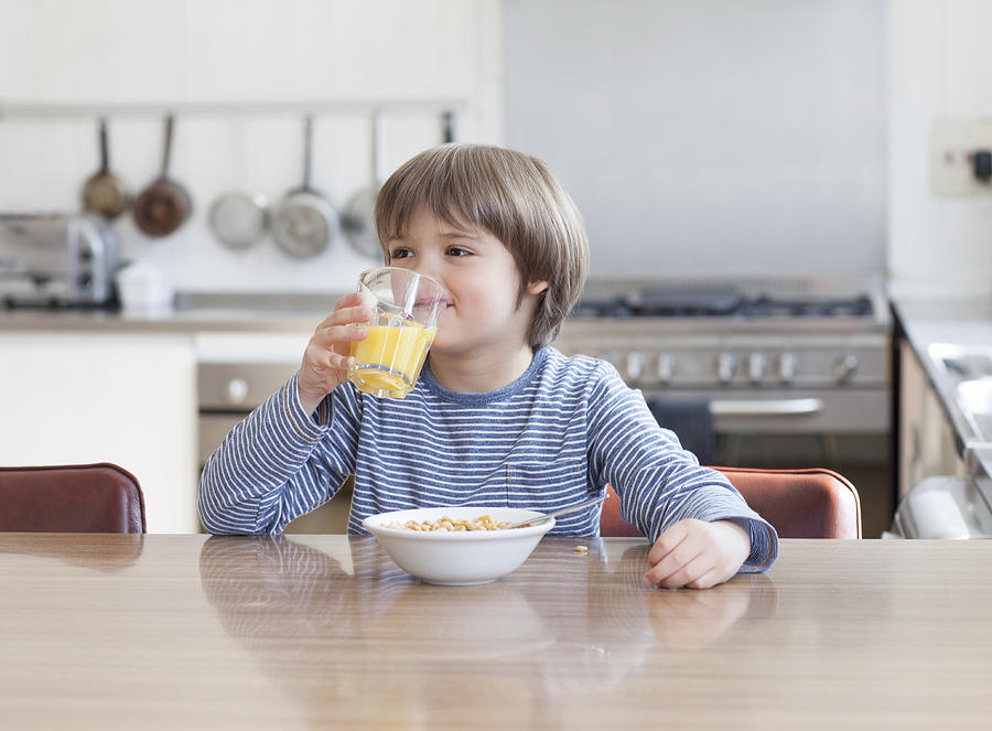 Boy eating breakfast in kitchen Photograph by Compassionate Eye Foundation/Natasha Alipour Faridani
